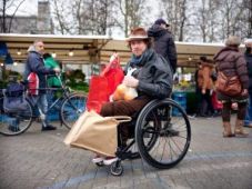Mari in rolstoel bepakt met boodschappentassen