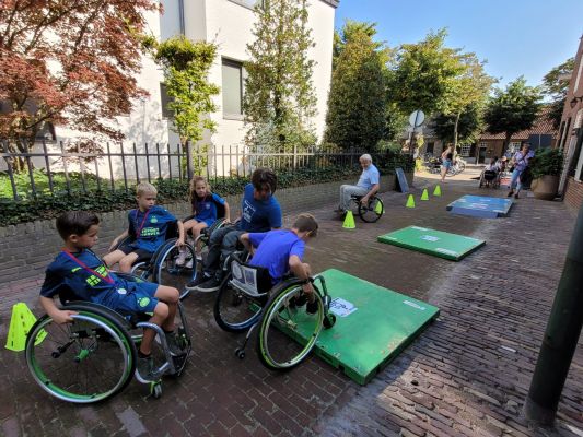 Enkele jeugdige renners doen mee aan de rolstoelvaardigheidscursus