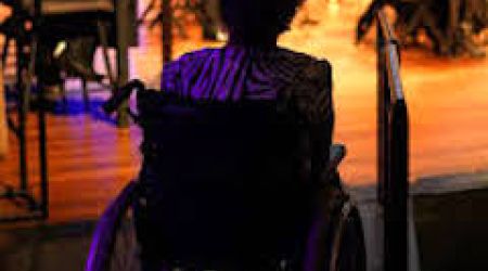 Vrouw in een rolstoel die een theater bezoekt