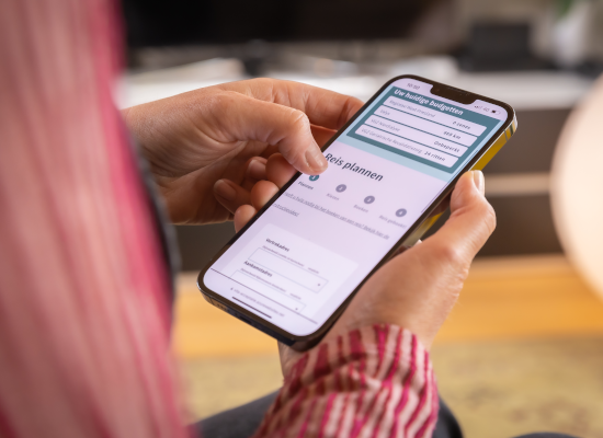 Een persoon met een mobiele telefoon die via de Vita app een taxi boekt