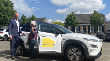 Wethouder helpt de eerste deelnemer van AutoMaatje mee uitstappen