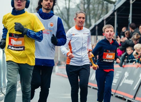 Een blind kind loopt een hardloopwedstrijd met zijn buddy