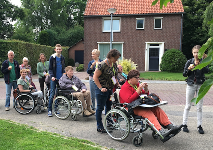 3e Rolstoel wandelevenement (een groep wandelaars inclusief mensen in rolstoel met duwer)