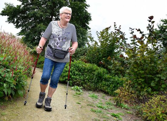 Twee wandelaars, lopen over het Pieterpad, waarvan een in een off-the-road rolstoel