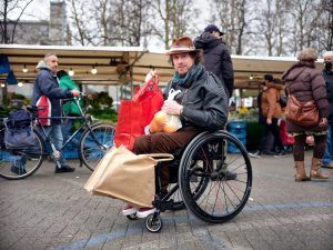 Mari Sanders in rolstoel bepakt met boodschappentassen
