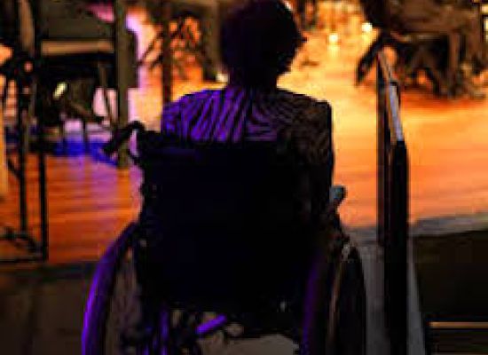 Vrouw in een rolstoel die een theater bezoekt