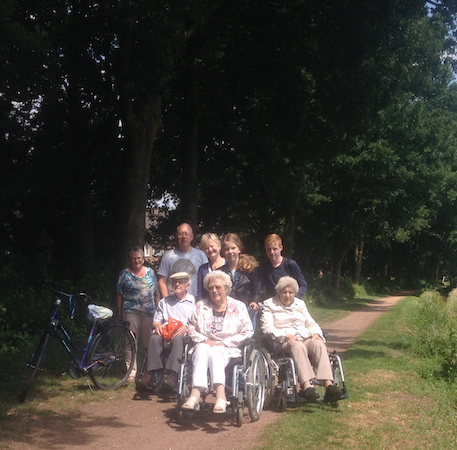 Groep wandelaars mensen in rolstoel met duwers