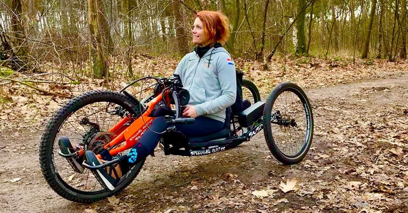 Sabrina op haar speciale handbike in de bossen