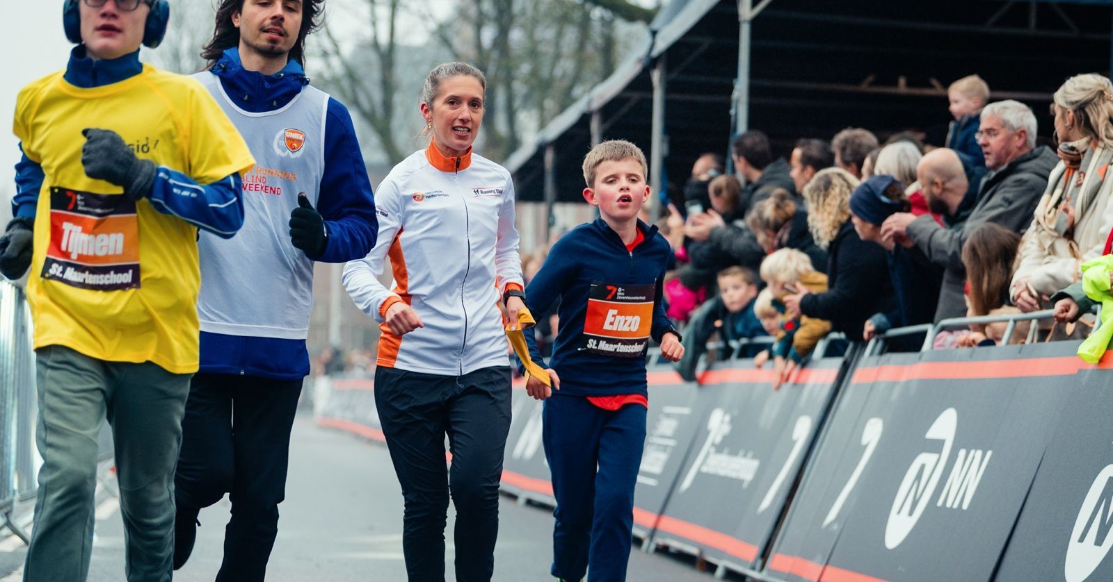 Een blind kind loopt een hardloopwedstrijd met zijn buddy