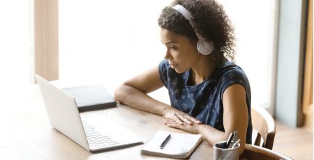 Meisje achter een laptop met koptelefoon op