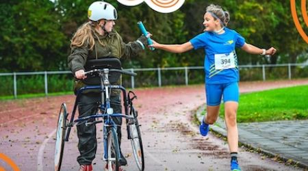Estafette met een kind op een frame runner en een kind dat hardloopt