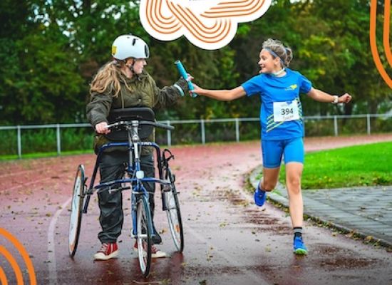 Estafette met een kind op een frame runner en een kind dat hardloopt