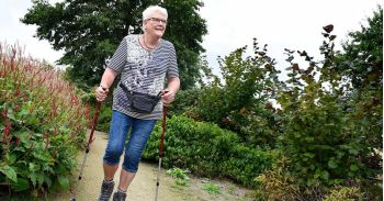 Mevrouw aan het wandelen met nordic walking stokken