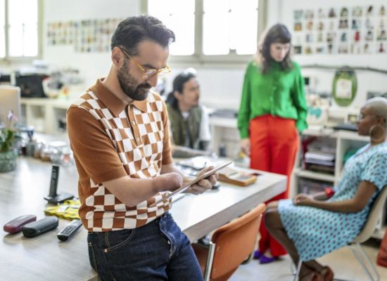 Persoon met een hand beperking leest op zijn tablet