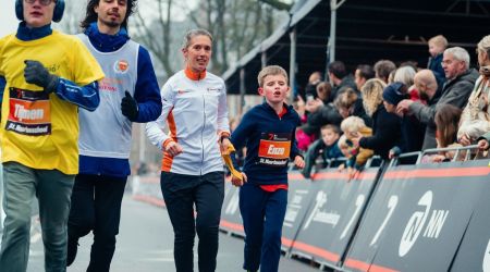 Een blind kind loopt een hardloopwedstrijd met zijn buddy