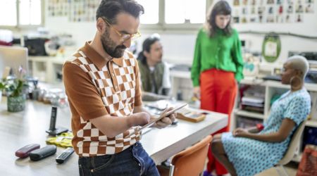 Persoon met een hand beperking leest op zijn tablet