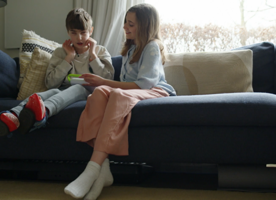 broertje en zusje aan het gamen zittende op de bank