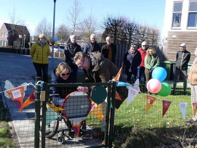 Lintjes worden doorgeknipt bij de ingang (poortje) van de Buurtvlindertuin