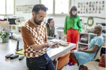 Persoon met een hand beperking leest op zijn tablet