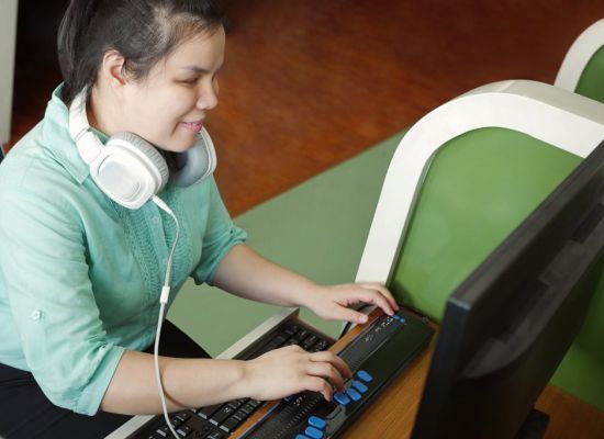 Slechtziend jonge vrouw achter de computer